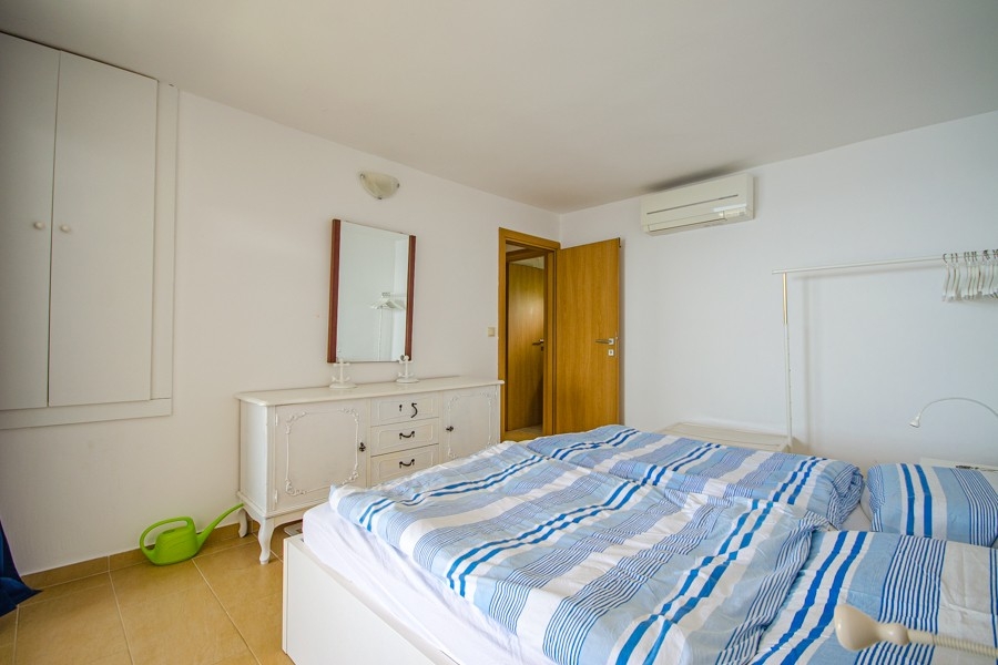 Sypialnia z klimatyzacją i prostym umeblowaniem