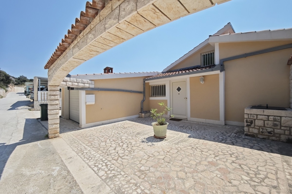 Fasada domu z garażem i utwardzonym podwórkiem