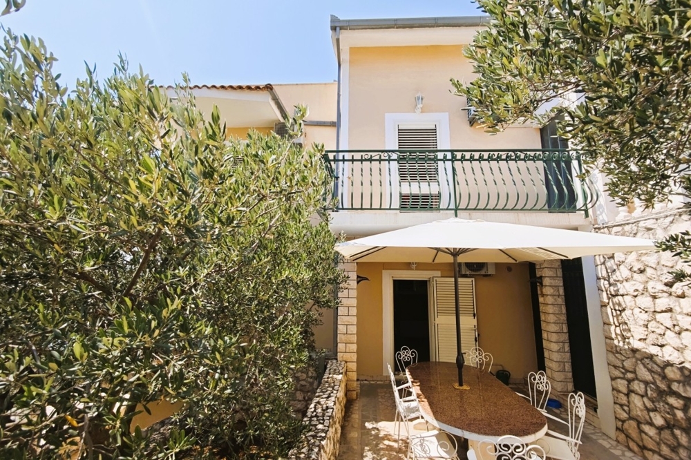 Zadaszony taras z częścią wypoczynkową i drzewami oliwnymi