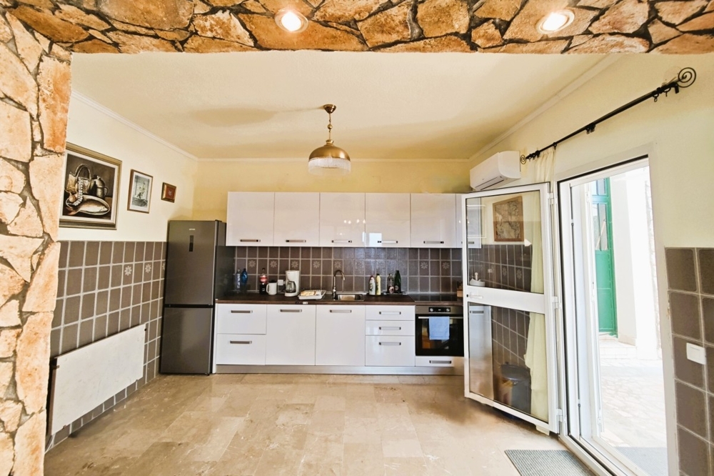 Kuchnia-salon z wyposażoną kuchnią i wyjściem na taras