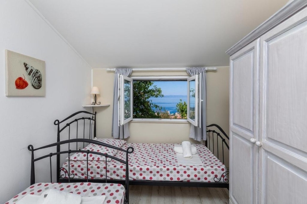 Sypialnia z pojedynczymi łóżkami i widokiem na morze przez okno