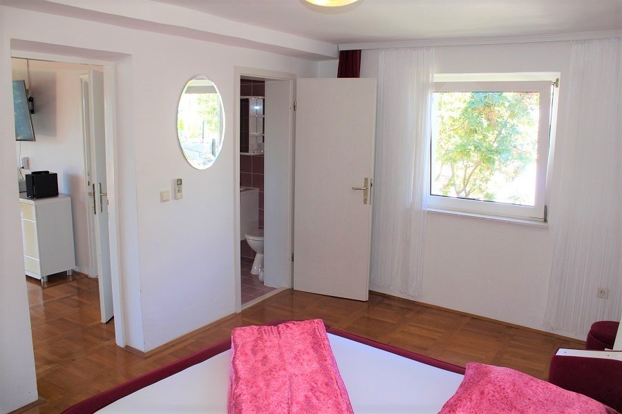 Sypialnia z dostępem do łazienki i widokiem na zieleń