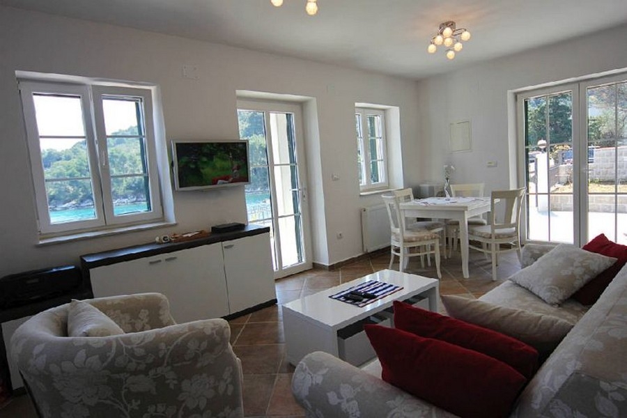 Jasny salon z dużymi oknami i widokiem na morze