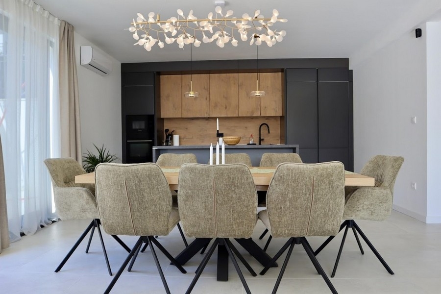 Jadalnia z designerską kuchnią i dużą ilością naturalnego światła