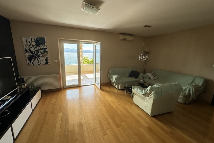 Pokój dzienny z podłogą drewnianą i wyjściem na balkon