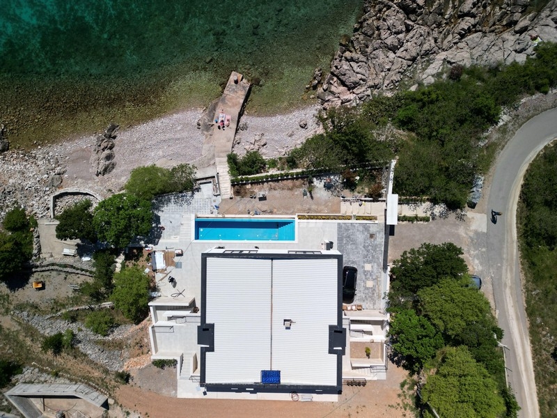 Widok z lotu ptaka na nieruchomość i basen z dostępem do plaży