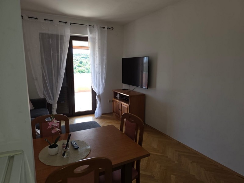 Pokój dzienny ze stołem, telewizorem i drzwiami tarasowymi