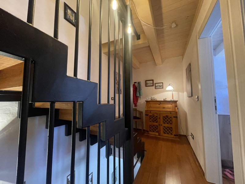 Klatka schodowa z metalowymi balustradami i korytarzem na piętrze