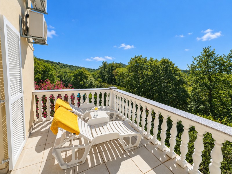 Balkon z leżakami i widokiem na zieleń