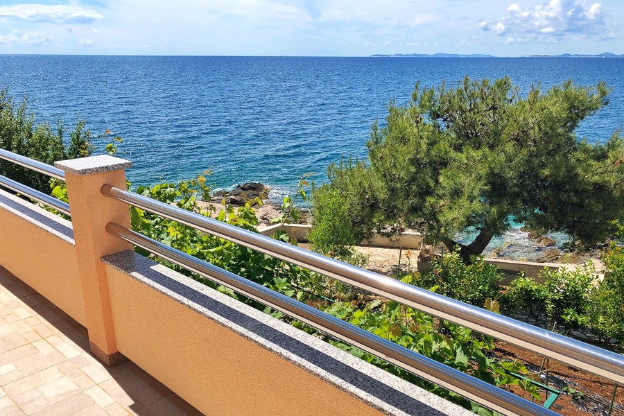 Balkon z widokiem na sosny i morze