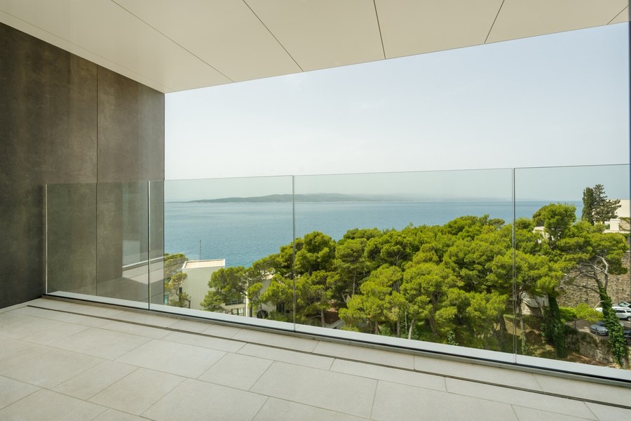 Balkon ze szklaną balustradą i widokiem na morze