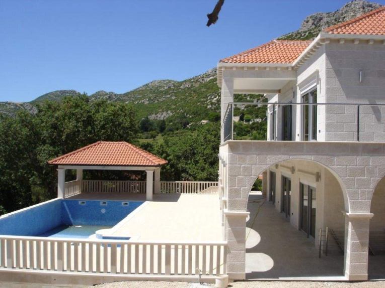 Teren zewnętrzny z basenem i tarasami.